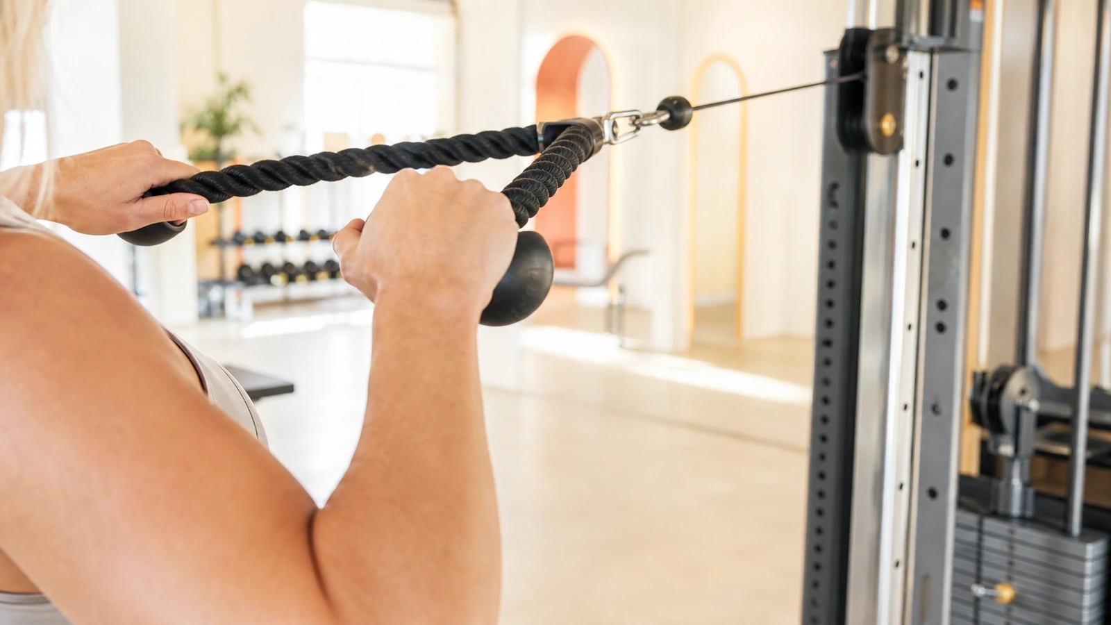 Tjockt rephandtag på kabelmaskin hängande framför träpanelvägg i gym, ingen person synlig