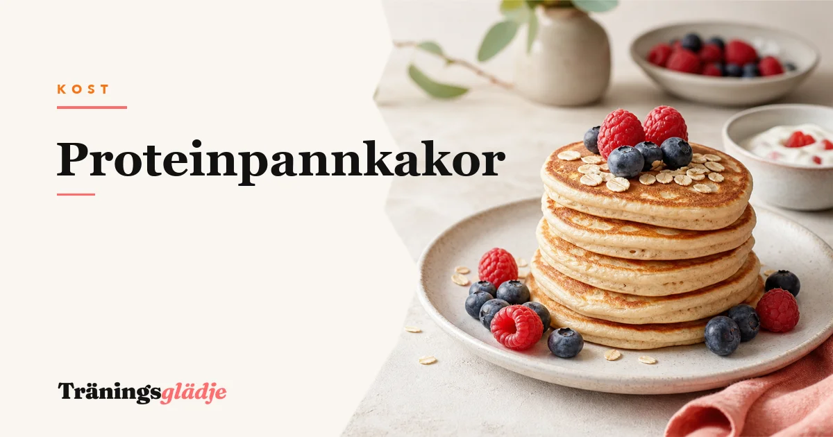 Fluffiga proteinpannkakor staplade på vit tallrik med färska blåbär, hallon och en klick kvarg, lönnsirap rinner ned över sidan